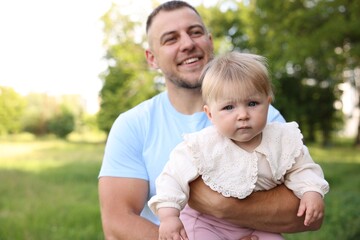 Fototapeta premium Smiling dad and his newborn baby outdoors. Happy Father's Day