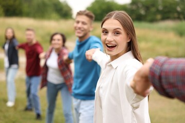 Team building. Group of happy people holding hands outdoors, selective focus