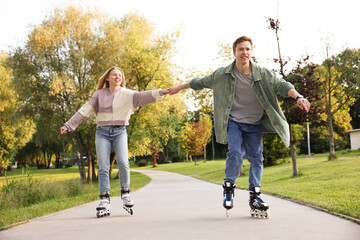 Happy couple roller skating together in park