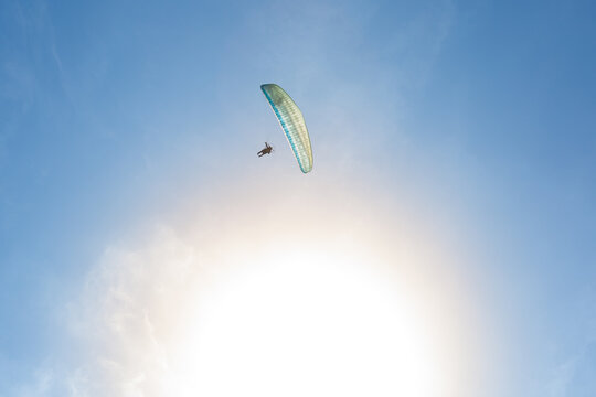Paramotor flying alone with the sun in the background