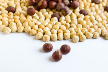 Shelled and unshelled, double roasted, luxury Turkish hazelnuts, designed together on a white surface