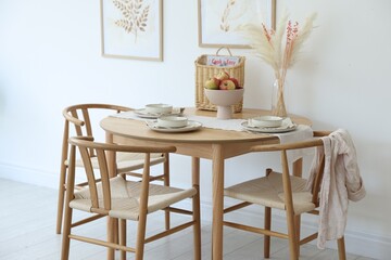 Beautiful table setting, chairs and decor in dining room. Interior design