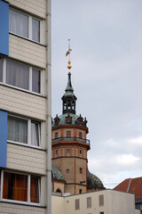 Fototapeta premium Elegant historical architecture tower. Ornate spires and rooftop details. Contrasting modern building nearby. Urban cityscape with evening sky. High resolution detailed city photo.