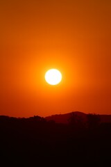 Pôr do sol intenso com céu em tons de vermelho e laranja sobre silhuetas de montanhas. Uma cena dramática e serena, perfeita para representar a beleza natural, a paz e a contemplação.