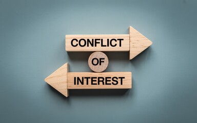 Conceptual image representing conflict of interest with wooden blocks and arrows on a blue background.