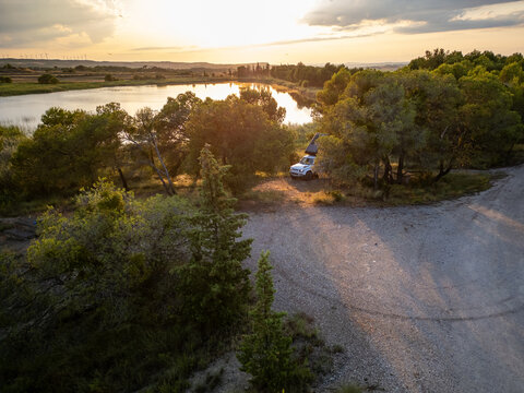 Romantic Camping at the lake with 4x4 Offroad vehicle with roof tent at sundown