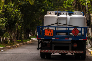 Truck carrying flammable gas cylinders in an urban area in Brazil. Illustrates challenges and risks of transporting hazardous materials.