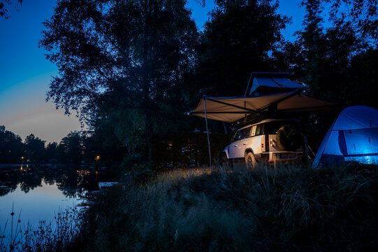 Romantic Camping at the lake with 4x4 Offroad vehicle with roof tent at night