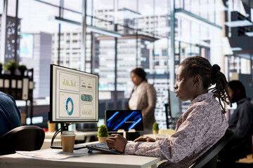 African american businesswoman managing administrative tasks at desk, reviewing organizational...
