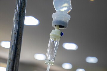 Close-up of an IV drip with visible fluid and bubbles, suggesting a hospital setting. Medical...