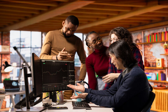 Cheerful startup team cheering after seeing live market updates showing stocks raising, becoming profitable. Joyous venture staff members overjoyed after becoming publicly traded company