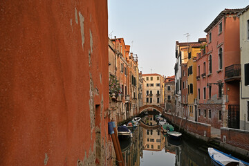 Streets and canals of Venice. Houses and boats, reflections in the water.