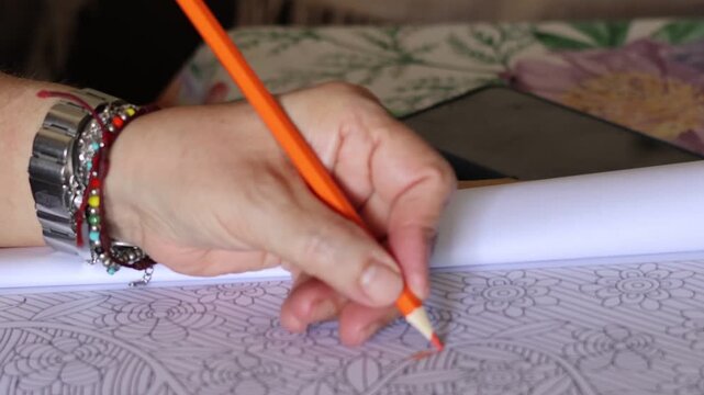 mano lapiz naranja haciendo mandala