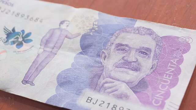 Primer plano de un billete de cincuenta mil pesos colombianos, color morado, tomado en un movimiento de traveling