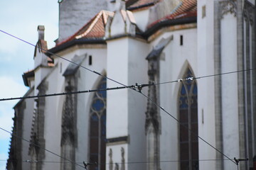 gothic church, tram wires, historic architecture, city infrastructure, stained glass, old building, urban landscape, medieval style, European city, power lines, cultural heritage, travel