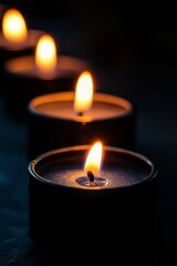 A row of glowing black candles on a dark surface creating an atmospheric ambiance