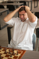 Middle aged Caucasian man playing chess. 