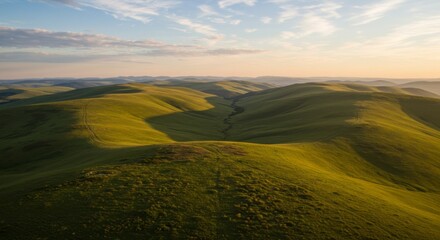 Fototapeta premium Aerial View of Rolling Green Hills at Sunset