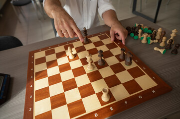 Close up of hands of middle aged caucasian man playing chess. 
