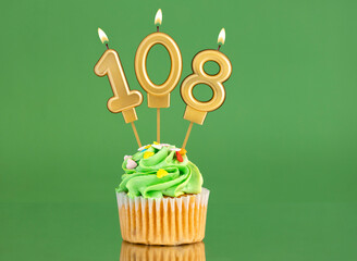 Number 108 birthday candle - Cupcake on a green background