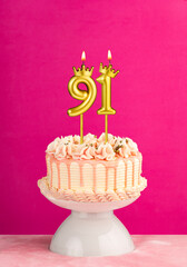 Pink birthday celebration cake with number 91 candle
