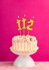 Number 112 birthday candle - Pink celebration cake with drip icing