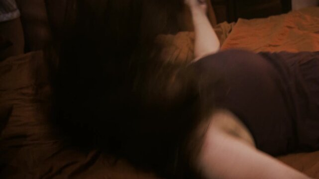 woman writhes on a bed during an exorcism