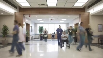 Time-lapse of busy medical staff and patients in a modern hospital lobby. - Powered by Adobe