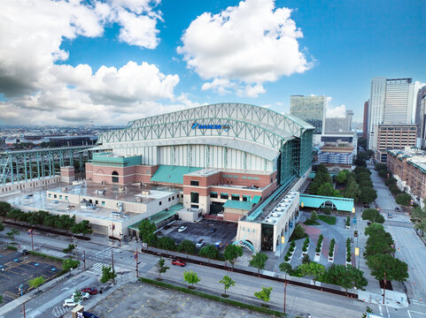 Stunning aerial drone view of Minute Maid Park in downtown Houston, Texas. Captured on a bright day with scattered clouds and vivid blue sky. Photo take 4 15 2025 in Houston, TX.