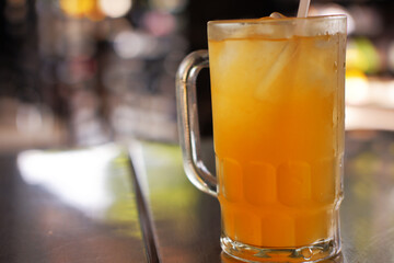 A glass of iced orange juiced with blurred background, A refreshing drink for hot weather