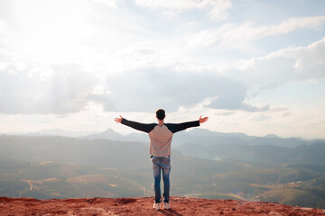 Brazilian man with arms wide open facing the mountains. A moment of freedom, mindfulness, and...
