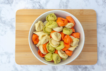 Tortolloni placed in a white bowl. 