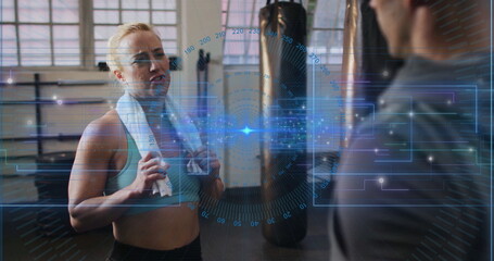 Catching breath woman wearing sportswear with towel in gym near punching bag with HUD, copy space