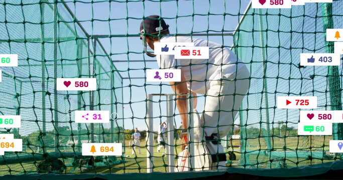 Leaning batsman wearing white kit holding bat in net cage on field, with social media icons - Powered by Adobe