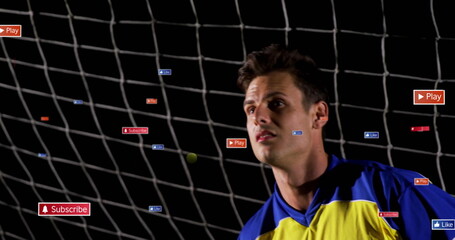 Standing athlete in yellow blue jersey at studio with net backdrop, icons, green ball, copy space