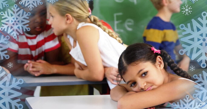 Resting girl with braids lying head on arms at classroom desk, with snowflake graphics, copy space