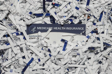 Medicare Card partially hidden amongst shredded documents.