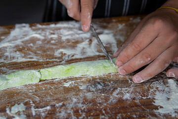 Artisan cooking: portioning vibrant green dough for Italian pasta
