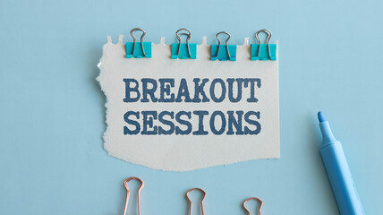 BREAKOUT SESSIONS - words on white sheet on a black leather book with pen. Business concept.