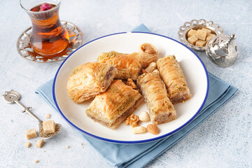Plate with tasty baklava on light background