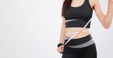 Holding the tape at her waist and another tape for double-check, the slim woman shows signs of...