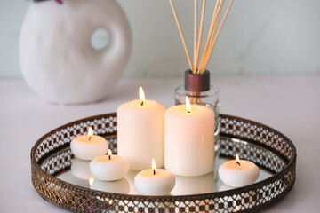 Tray with burning candles on white background