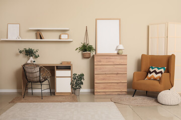 Interior of stylish living room with soft armchair, chest of drawers, workplace and houseplant
