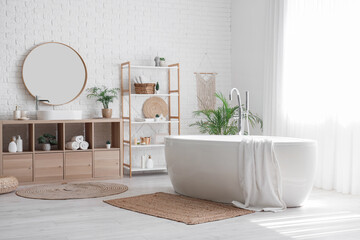 Interior of bathroom with bathtub, surfboard and houseplant