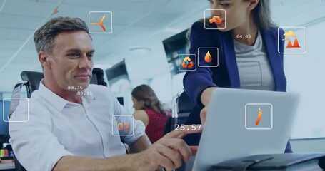 Analyst typing on laptop as coworker pointing showing carbon and flame overlay for energy analysis - Powered by Adobe