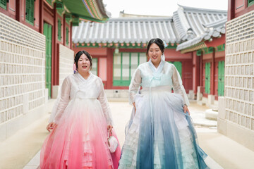 Seoul, June 2025: Two Korean women in their twenties stroll through Gyeongbokgung Palace's halls...