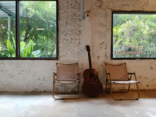 Old chair and guitar in the living room, vintage style, stock photo