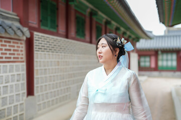 In Seoul in June 2025, a Korean woman in her twenties walks in front of the traditional facade of...