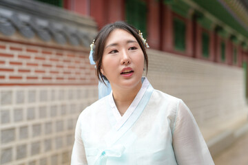 In Seoul in June 2025, a Korean woman in her twenties walks in front of the traditional facade of...