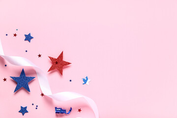 Paper stars with ribbon in colors of USA flag for Independence Day on pink background